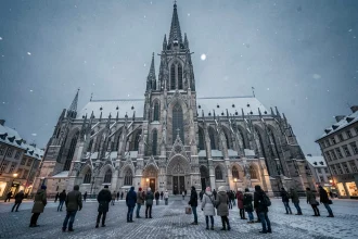 La cathédrale de Strasbourg sous la neige lors du Nouvel An avec une foule de visiteurs sur la place enneigée