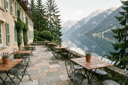 Terrasse d'un hôtel en bord de lac en Auvergne-Rhône-Alpes avec vue sur les montagnes alpines et l'eau calme